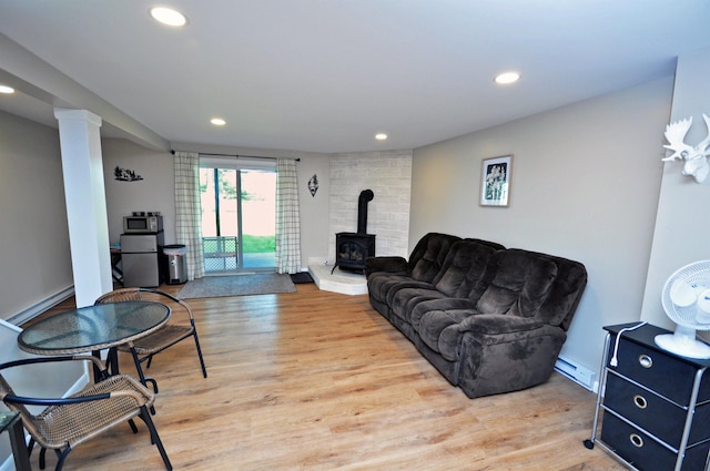 17 Village W Dr Unit 11, Bristol, NH 03222 - living area featuring a wood stove, recessed lighting, light wood-type flooring, baseboard heating, and ornate columns