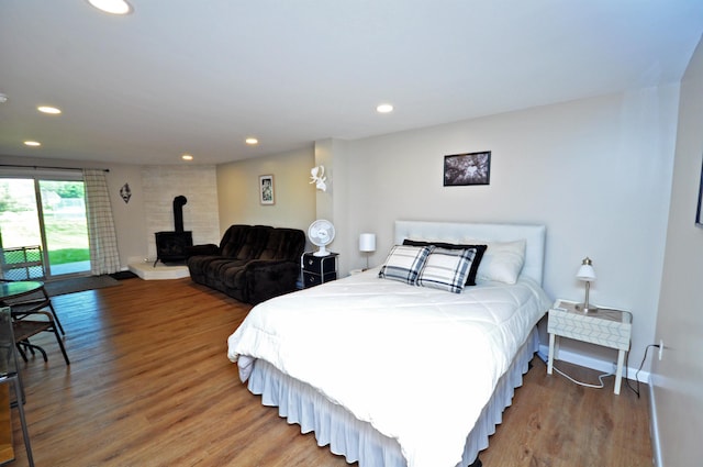 17 Village W Dr Unit 11, Bristol, NH 03222 - bedroom featuring a wood stove, wood finished floors, access to exterior, and recessed lighting