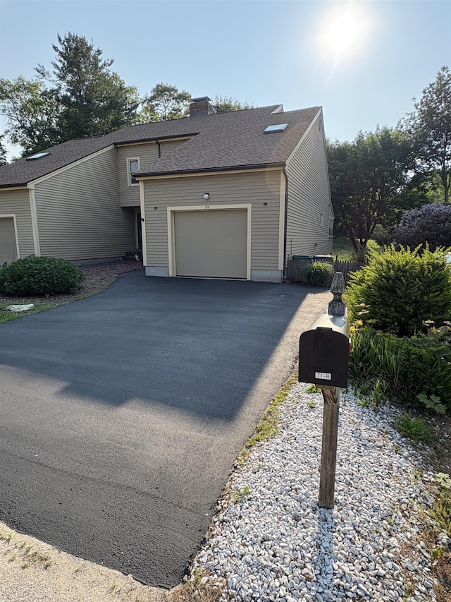 71 Esker Rd Unit B, Hampton, NH 03842 - view of front facade featuring a garage, driveway, a chimney, and a shingled roof