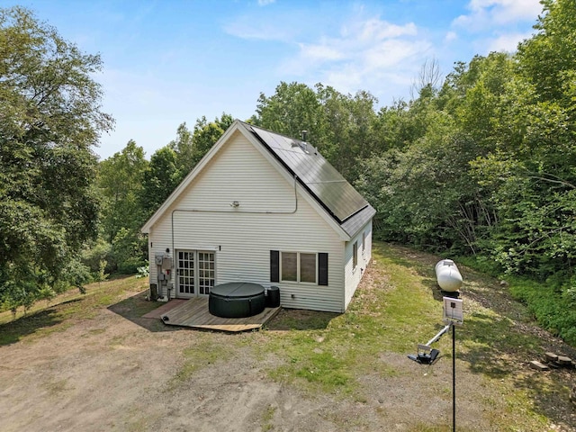 592 Old Bristol Rd, New Hampton, NH 03256 - back of house featuring a hot tub, a deck, and solar panels