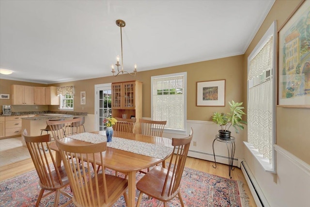 236 Lefebvre Ln, Williston, VT 05495 - dining room featuring light wood finished floors, crown molding, a baseboard heating unit, a chandelier, and a wainscoted wall