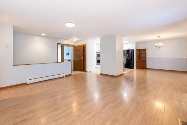 11 Penny Ln, Laconia, NH 03246 - unfurnished living room featuring baseboard heating, a chandelier, and light wood finished floors