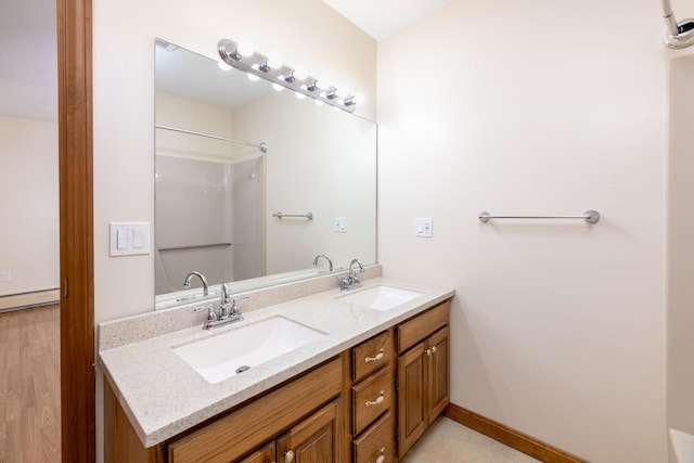 11 Penny Ln, Laconia, NH 03246 - bathroom with double vanity, a shower, a baseboard heating unit, and wood finished floors