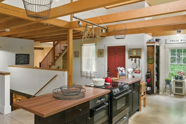 130A Amherst St, Amherst, NH 03031 - kitchen featuring butcher block countertops, stainless steel range with electric stovetop, dark cabinetry, a kitchen island, and concrete floors