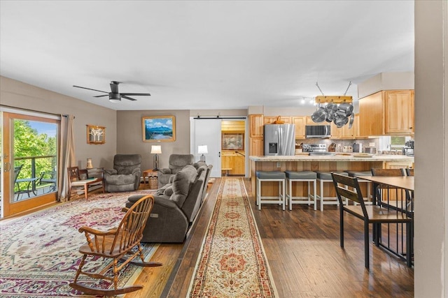 564 St Albans Rd, Swanton, VT 05488 - living room featuring dark wood finished floors, ceiling fan, and a barn door