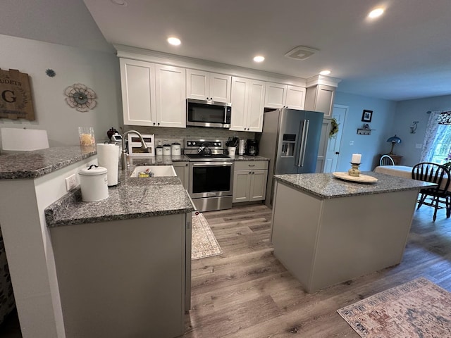 326 Dublin Rd, Jaffrey, NH 03452 - kitchen with stainless steel appliances, light wood-style floors, a center island, decorative backsplash, and recessed lighting
