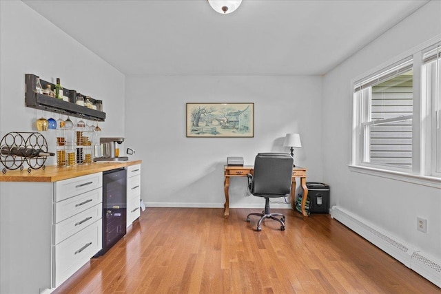 33 Winterlane Cir, Essex, VT 05452 - office area featuring a baseboard radiator, wine cooler, a dry bar, and light wood-style flooring