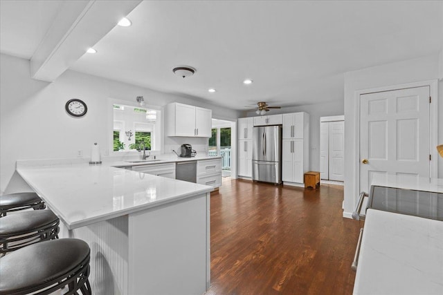 33 Winterlane Cir, Essex, VT 05452 - kitchen featuring appliances with stainless steel finishes, a peninsula, a kitchen bar, dark wood-style flooring, and recessed lighting