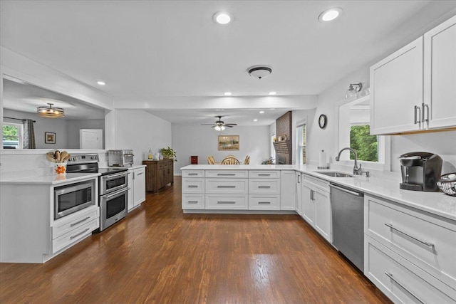 33 Winterlane Cir, Essex, VT 05452 - kitchen featuring stainless steel appliances, a peninsula, dark wood-type flooring, white cabinets, and recessed lighting