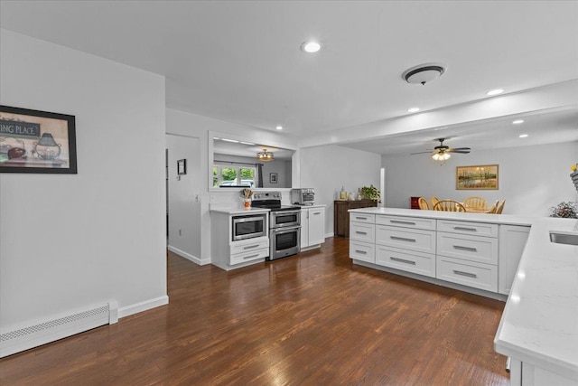 33 Winterlane Cir, Essex, VT 05452 - kitchen with appliances with stainless steel finishes, a baseboard radiator, dark wood-style flooring, white cabinets, and a peninsula