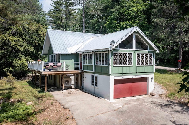 35 Alpstrausse Rd, Bartlett, NH 03845 - view of front facade featuring asphalt driveway, a wooden deck, a garage, a metal roof, and view of wooded area