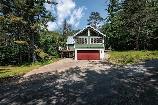 35 Alpstrausse Rd, Bartlett, NH 03845 - view of front of house with asphalt driveway, a garage, a metal roof, a wooded view, and a deck