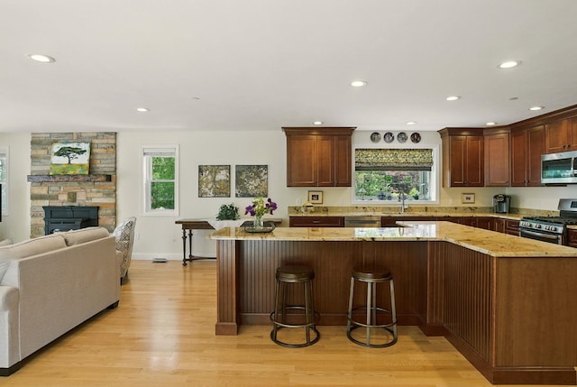 9 Blake Rd, Salem, NH 03079 - kitchen featuring appliances with stainless steel finishes, light wood-style floors, light stone counters, recessed lighting, and open floor plan