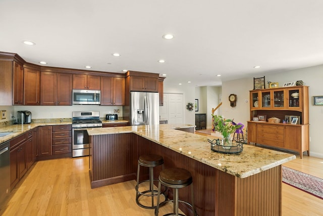 9 Blake Rd, Salem, NH 03079 - kitchen featuring stainless steel appliances, light wood-type flooring, a kitchen island, recessed lighting, and light stone counters