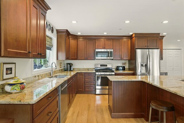 9 Blake Rd, Salem, NH 03079 - kitchen with appliances with stainless steel finishes, light wood finished floors, recessed lighting, light stone counters, and a kitchen bar