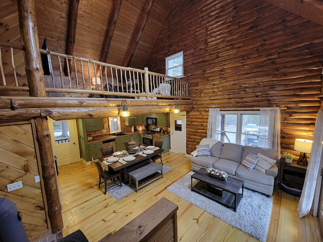 59 Ossipee Mountain Rd, Ossipee, NH 03814 - living area with high vaulted ceiling, wood-type flooring, a wooden ceiling with exposed beams, and rustic walls