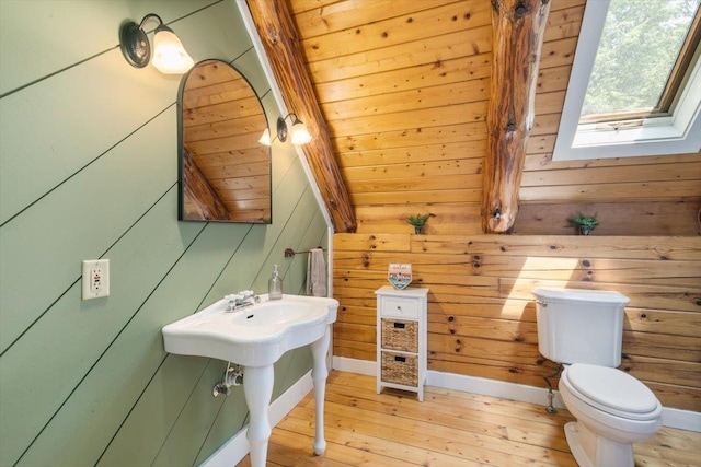 59 Ossipee Mountain Rd, Ossipee, NH 03814 - half bathroom featuring wood-type flooring, a skylight, and wood walls