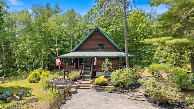 59 Ossipee Mountain Rd, Ossipee, NH 03814 - view of front of house with covered porch, stairs, a chimney, and log exterior