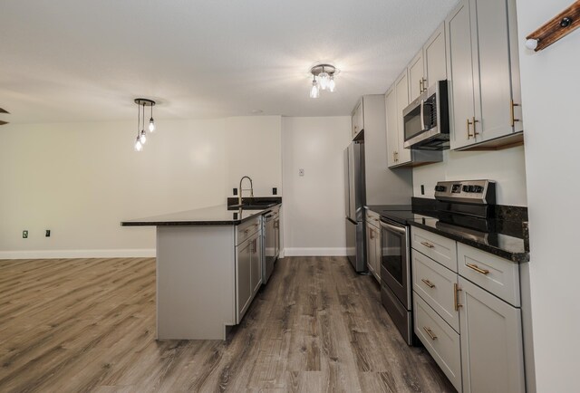 120 Fisherville Rd Unit 8, Concord, NH 03303 - kitchen with appliances with stainless steel finishes, dark countertops, dark wood-style flooring, and a peninsula
