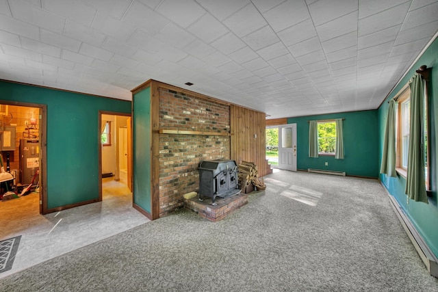 14 W Court Rd, Sunapee, NH 03782 - unfurnished living room featuring a baseboard heating unit, a wood stove, carpet floors, water heater, and a baseboard radiator