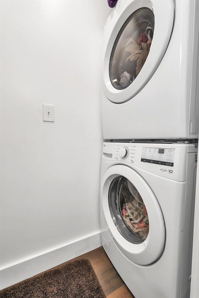 57 Central St, Farmington, NH 03835 - laundry room featuring stacked washer / drying machine and dark wood finished floors