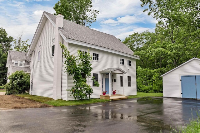 57 Central St, Farmington, NH 03835 - colonial inspired home featuring a chimney, a shingled roof, and an outbuilding