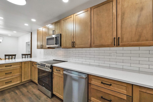 57 Central St, Farmington, NH 03835 - kitchen featuring stainless steel appliances, dark wood-type flooring, a peninsula, recessed lighting, and light countertops