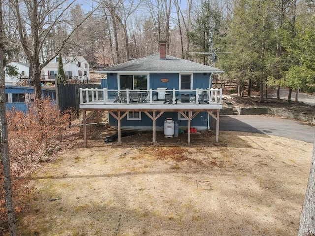 7 Reservoir Rd, Otis, MA 01253 - view of front of home featuring a deck, a chimney, roof with shingles, and view of wooded area