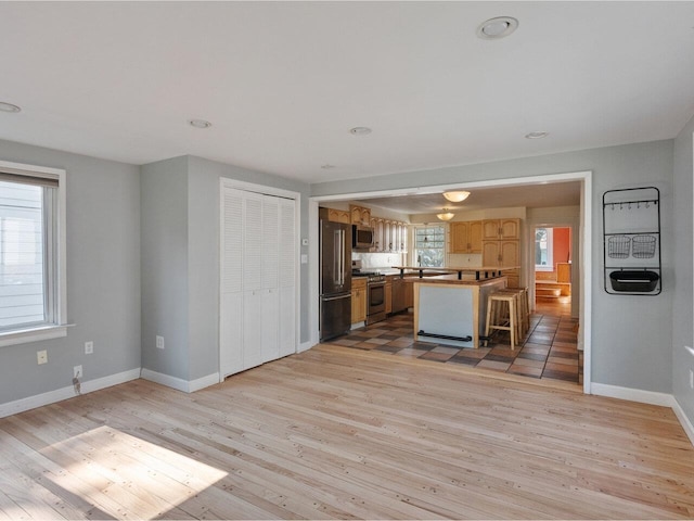 159 Loomis St, Burlington, VT 05401 - kitchen with stainless steel appliances, light wood finished floors, a kitchen breakfast bar, and recessed lighting