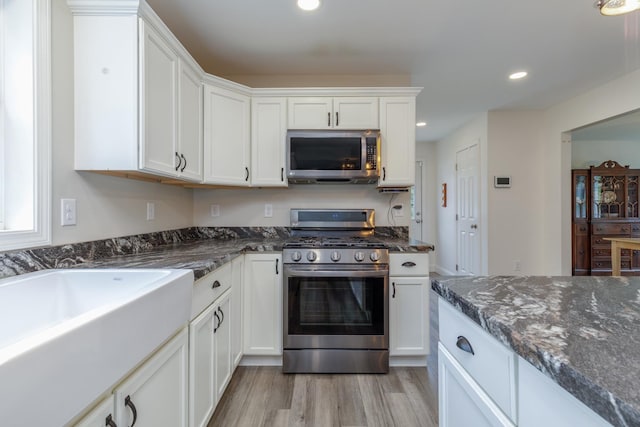 5 Turnpike St, Pembroke, NH 03275 - kitchen featuring appliances with stainless steel finishes, white cabinets, dark stone counters, light wood finished floors, and recessed lighting