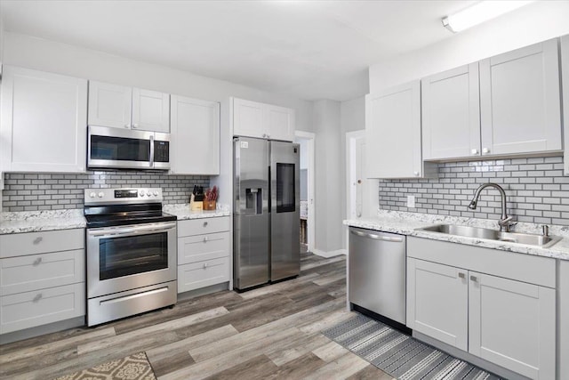226 N St, Bennington, VT 05201 - kitchen with appliances with stainless steel finishes, tasteful backsplash, light wood-style floors, and light stone countertops
