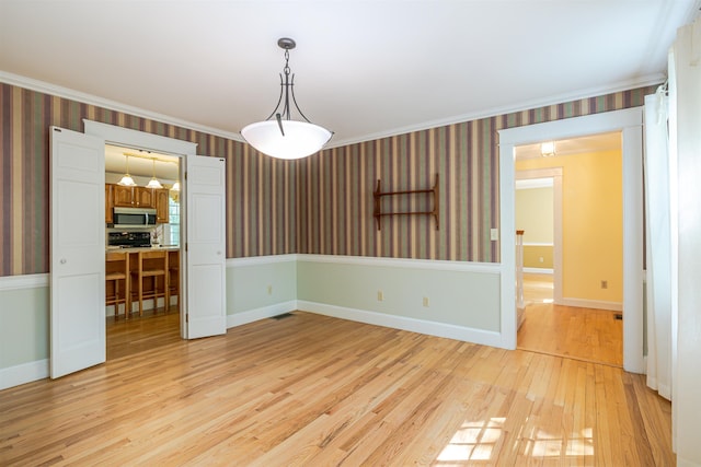 4 Spaulding St, Concord, NH 03301 - empty room with wallpapered walls, light wood-style floors, and crown molding