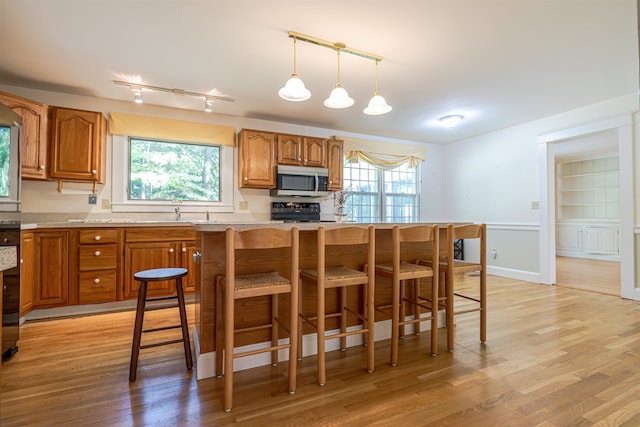 4 Spaulding St, Concord, NH 03301 - kitchen with stainless steel microwave, brown cabinets, light wood-style floors, and light countertops