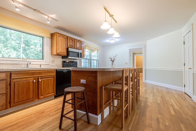 4 Spaulding St, Concord, NH 03301 - kitchen featuring stainless steel microwave, rail lighting, dishwasher, brown cabinets, and light wood-style floors