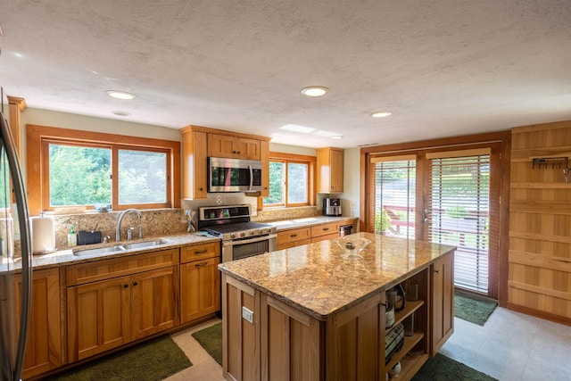 14 Mountain Ridge Rd, Ossipee, NH 03814 - kitchen with appliances with stainless steel finishes, a center island, light stone counters, brown cabinetry, and recessed lighting