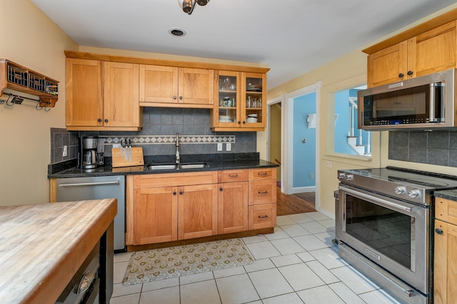 400 Turkey St, Tamworth, NH 03886 - kitchen featuring stainless steel appliances, decorative backsplash, glass insert cabinets, dark stone countertops, and light tile patterned flooring