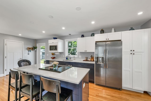 34 Leonard St, Rochester, NH 03867 - kitchen featuring stainless steel appliances, a kitchen breakfast bar, a kitchen island, white cabinetry, and recessed lighting