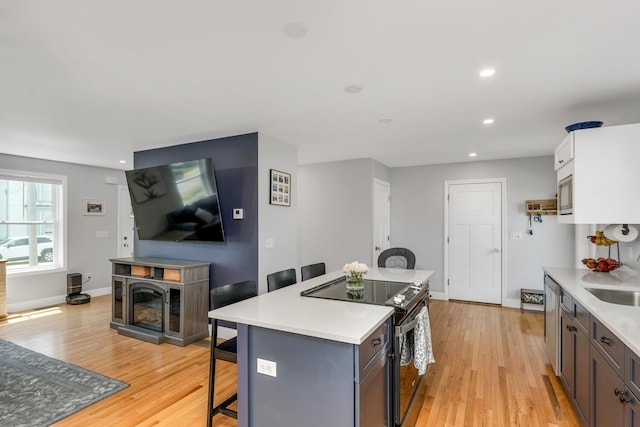 34 Leonard St, Rochester, NH 03867 - kitchen featuring range with electric cooktop, a breakfast bar area, a center island, light wood-style flooring, and recessed lighting
