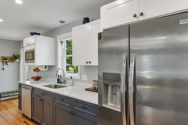 34 Leonard St, Rochester, NH 03867 - kitchen with appliances with stainless steel finishes, light countertops, light wood-style flooring, white cabinetry, and recessed lighting