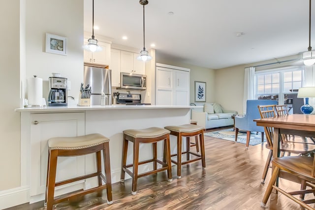 1 Ocean Ave Unit 210/212Fraction 3, York, ME 03909 - kitchen featuring stainless steel appliances, a breakfast bar area, dark wood finished floors, hanging light fixtures, and recessed lighting