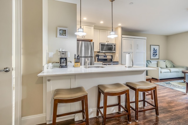 1 Ocean Ave Unit 210/212Fraction 3, York, ME 03909 - kitchen featuring stainless steel appliances, a kitchen breakfast bar, a peninsula, dark wood-style floors, and hanging light fixtures
