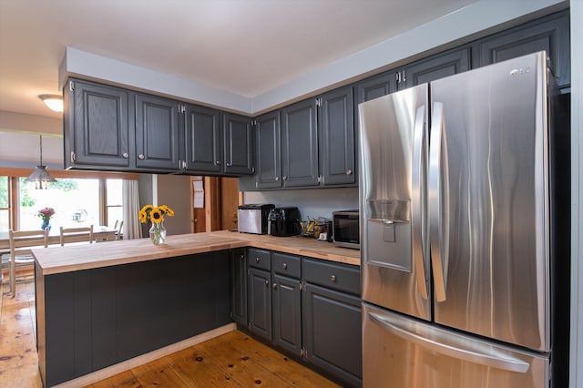 817 York Street Ext, Poultney, VT 05764 - kitchen featuring stainless steel appliances, gray cabinets, a peninsula, light wood-type flooring, and butcher block countertops