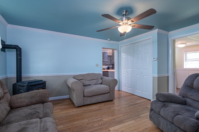 817 York Street Ext, Poultney, VT 05764 - living room featuring a wood stove, light wood-type flooring, ceiling fan, and crown molding