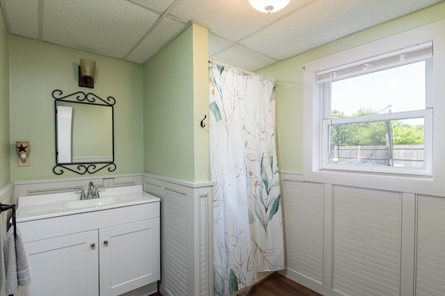 817 York Street Ext, Poultney, VT 05764 - bathroom featuring a wainscoted wall, a paneled ceiling, vanity, a shower with shower curtain, and a decorative wall