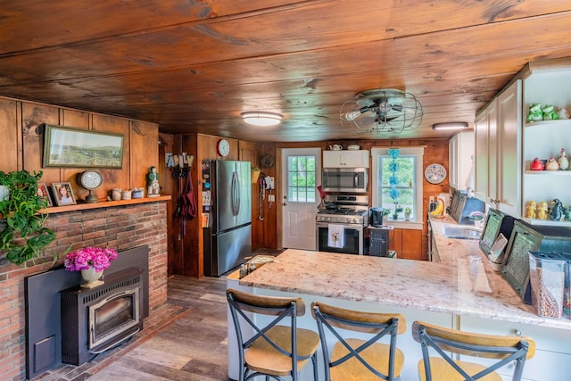 1307 Lime Kiln Rd, Haverhill, NH 03780 - kitchen with stainless steel appliances, a peninsula, wood finished floors, wooden ceiling, and light stone counters