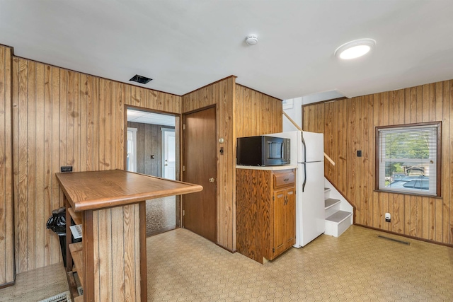 6 Davis Dr, Lebanon, NH 03766 - kitchen featuring wood walls, freestanding refrigerator, and light flooring