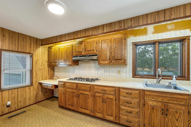 6 Davis Dr, Lebanon, NH 03766 - kitchen featuring stainless steel gas stovetop, under cabinet range hood, brown cabinets, light countertops, and wooden walls
