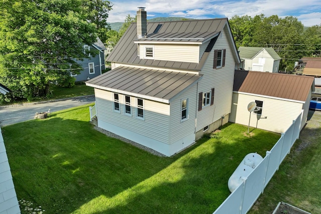 6 Davis Dr, Lebanon, NH 03766 - view of side of property featuring a standing seam roof, a metal roof, a chimney, and a fenced backyard