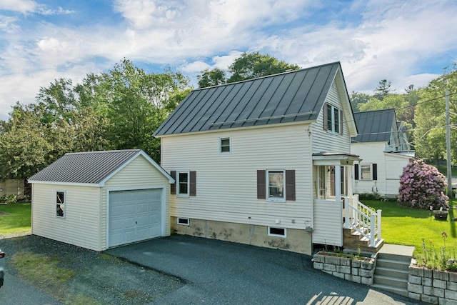 6 Davis Dr, Lebanon, NH 03766 - view of side of property with a standing seam roof, a metal roof, a garage, an outbuilding, and asphalt driveway
