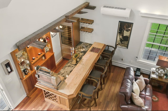 84 Shaw Rd, Northfield, NH 03276 - bar with wood finished floors, an AC wall unit, and baseboard heating